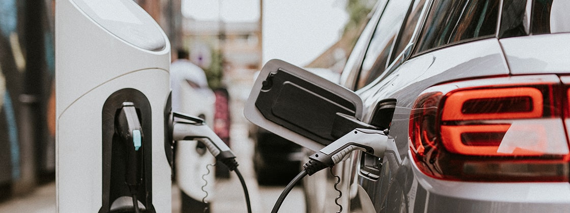 Electric vehicle charging at a public station with connected cables, showcasing sustainable fleet solutions